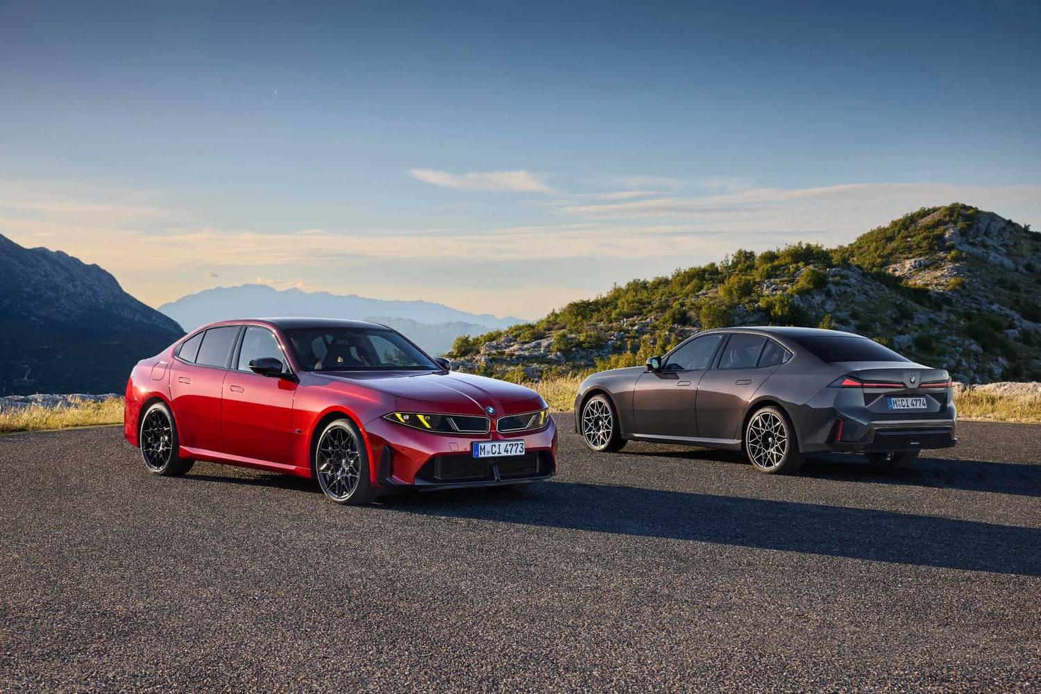 Czerwone BMW M350 xDrive i szare BMW serii 3 na górskim plateau