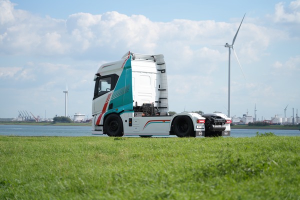 BYD ETT 44 elektryczny ciągnik 4x2 widziany z boku na tle elektrowni wiatrowych