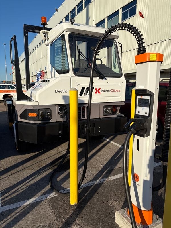 Elektryczny ciągnik terminalowy Kalmar Ottawa podłączony do ładowarki Kempower