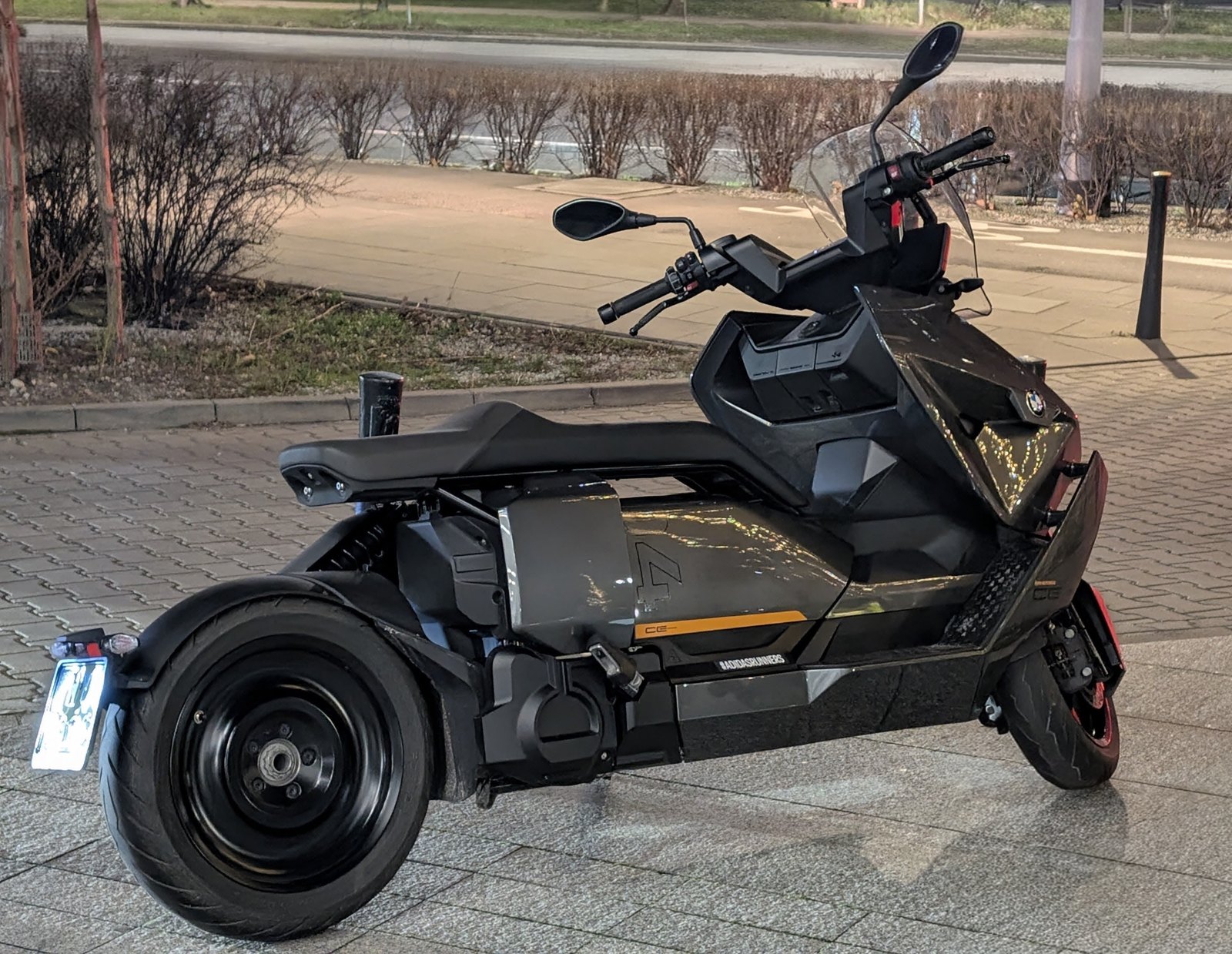 Elektryczny maxi-skuter zaparkowany na ulicy nocą – ilustracja do tematu Trinity Saturn GT 300