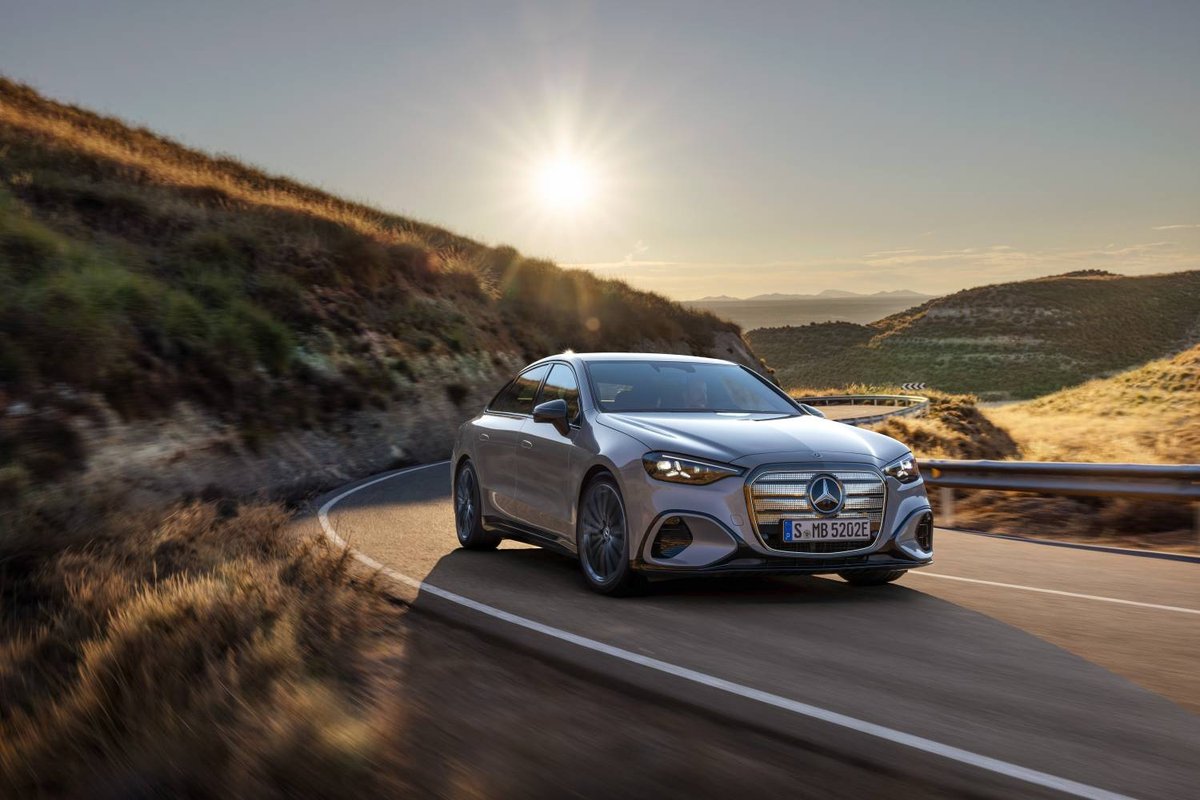 Mercedes-Benz C 300 4MATIC electric w zakręcie nadmorskiej drogi o zachodzie słońca