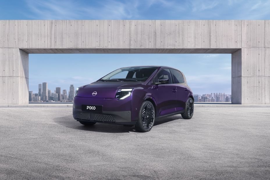 Fioletowy Nissan PIXO, miejski elektryk, widok z przedniego narożnika przy nowoczesnej konstrukcji