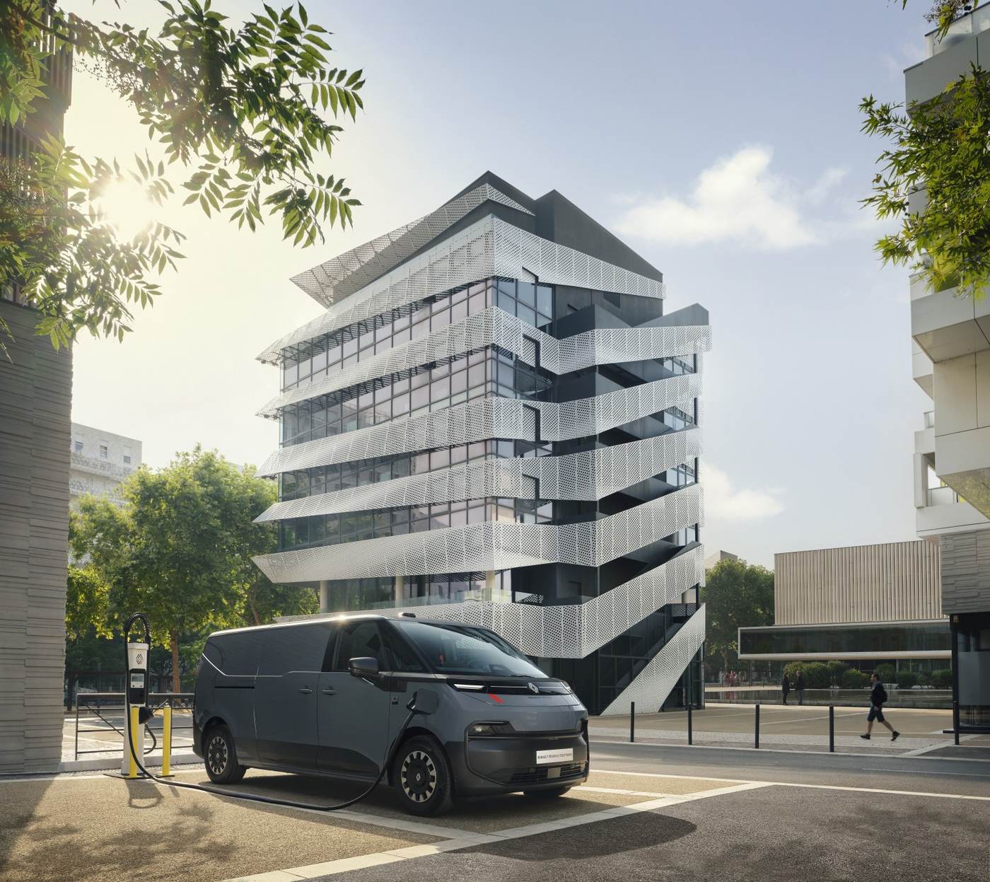 Renault Trucks E-Tech Trafic podłączony kablem do ładowarki przy nowoczesnym budynku