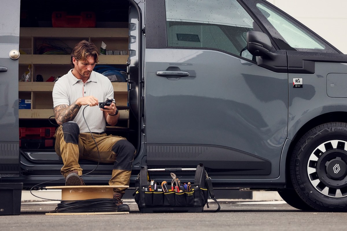 Technik pracujący przy otwartym tyle elektrycznego vana Renault Trucks z narzędziami