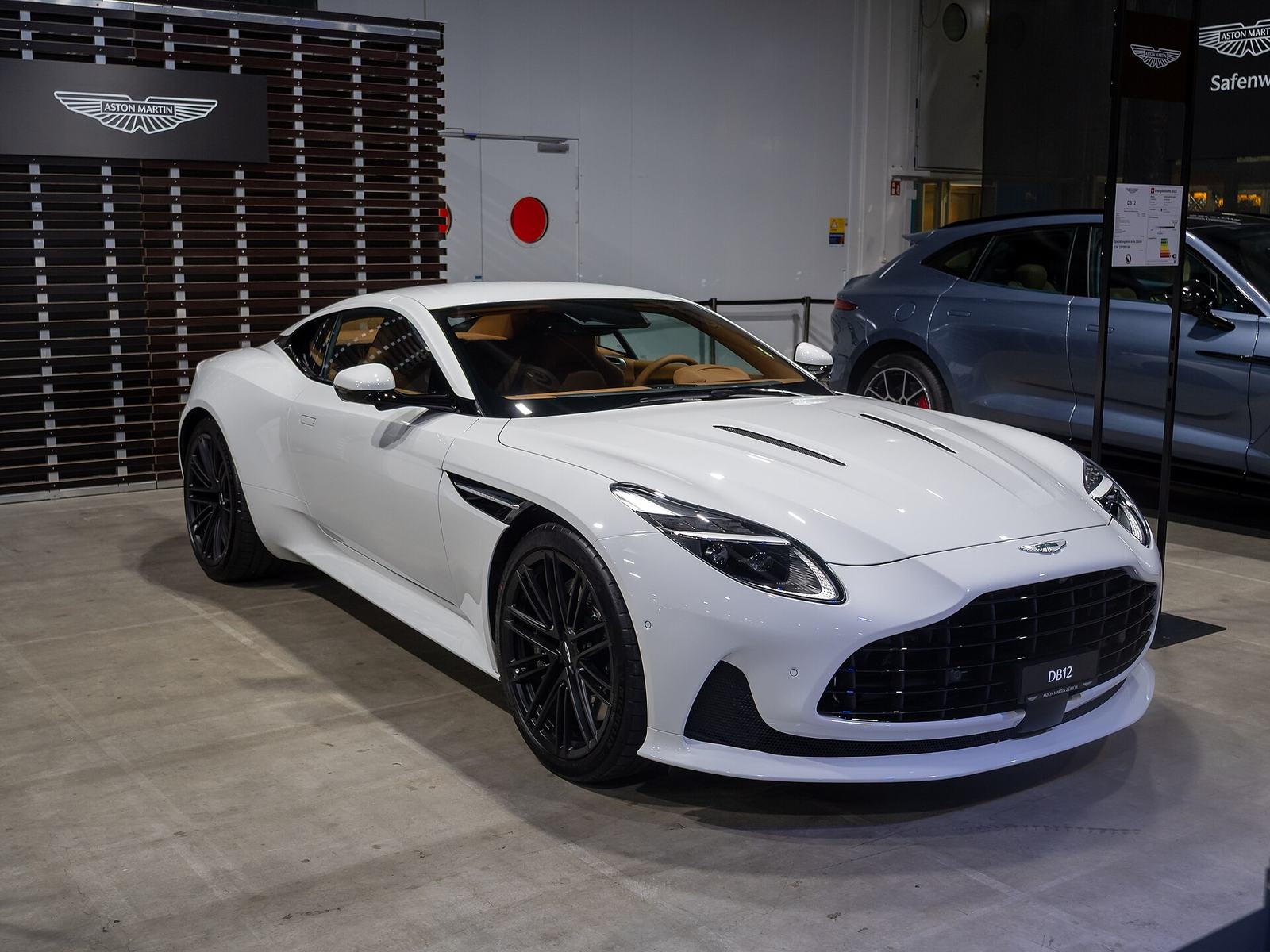 Biały Aston Martin DB12 na wystawie w salonie samochodowym w Zurychu
