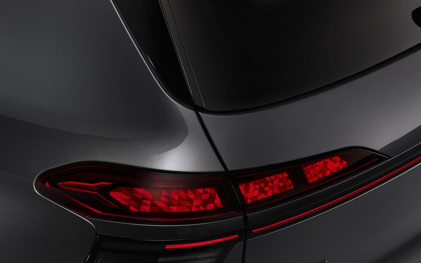 Zbliżenie na tylne światła OLED Audi Q9 z widocznymi segmentami cyfrowymi
