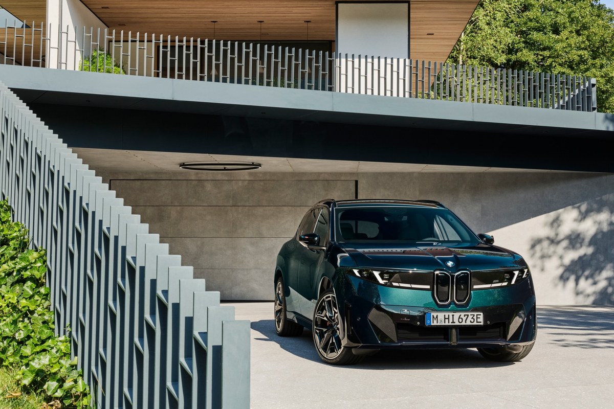 BMW iX3 M60 xDrive widziany z przodu, zaparkowany pod nowoczesnym carportem