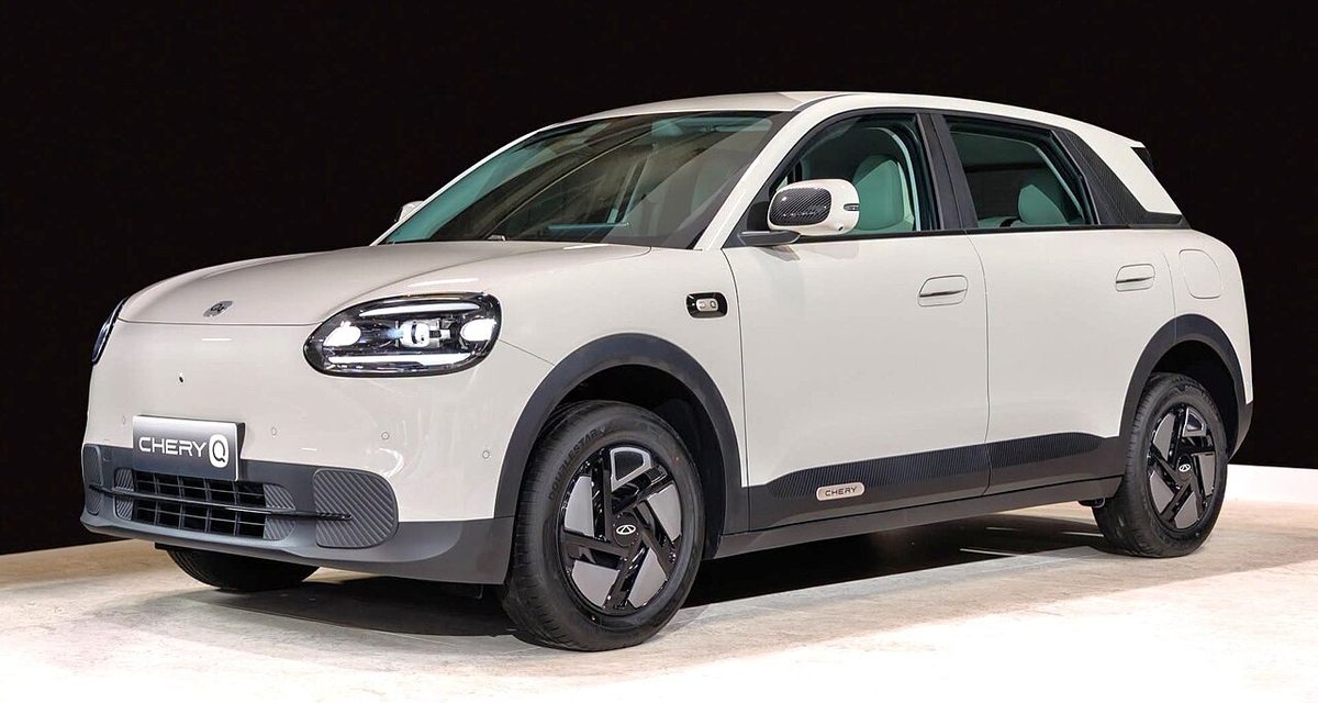 Chery Q, biały elektryk, widok z przodu i z boku na scenie wystawowej