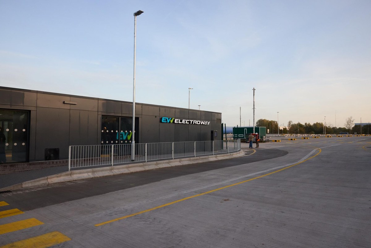 Ciemny budynek z logo EV Electroway, w którym mieści się zaplecze dla kierowców ciężarówek