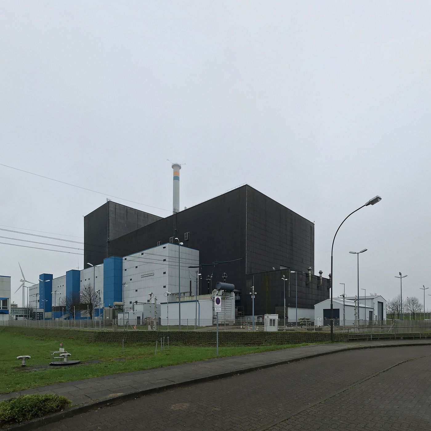 Budynki elektrowni jądrowej Brunsbüttel i turbiny wiatrowe w tle — miejsce inwestycji Vattenfall i Fluence