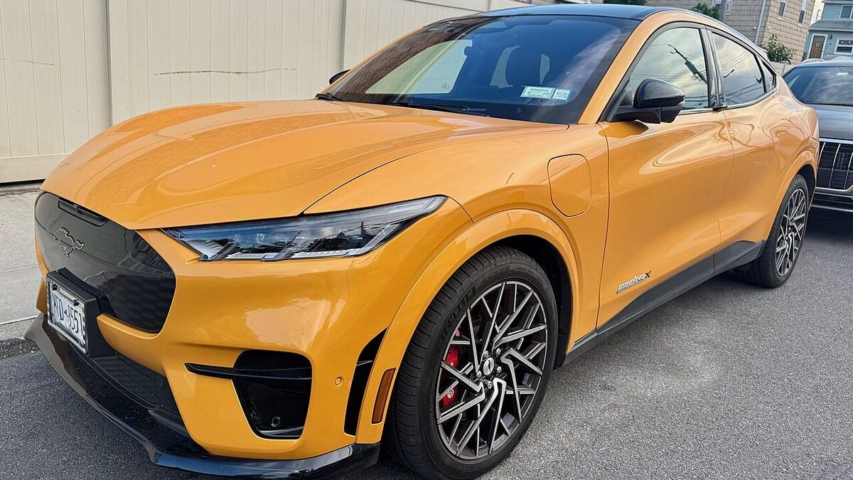 Pomarańczowy Ford Mustang Mach-E 2027 w wersji GT na parkingu