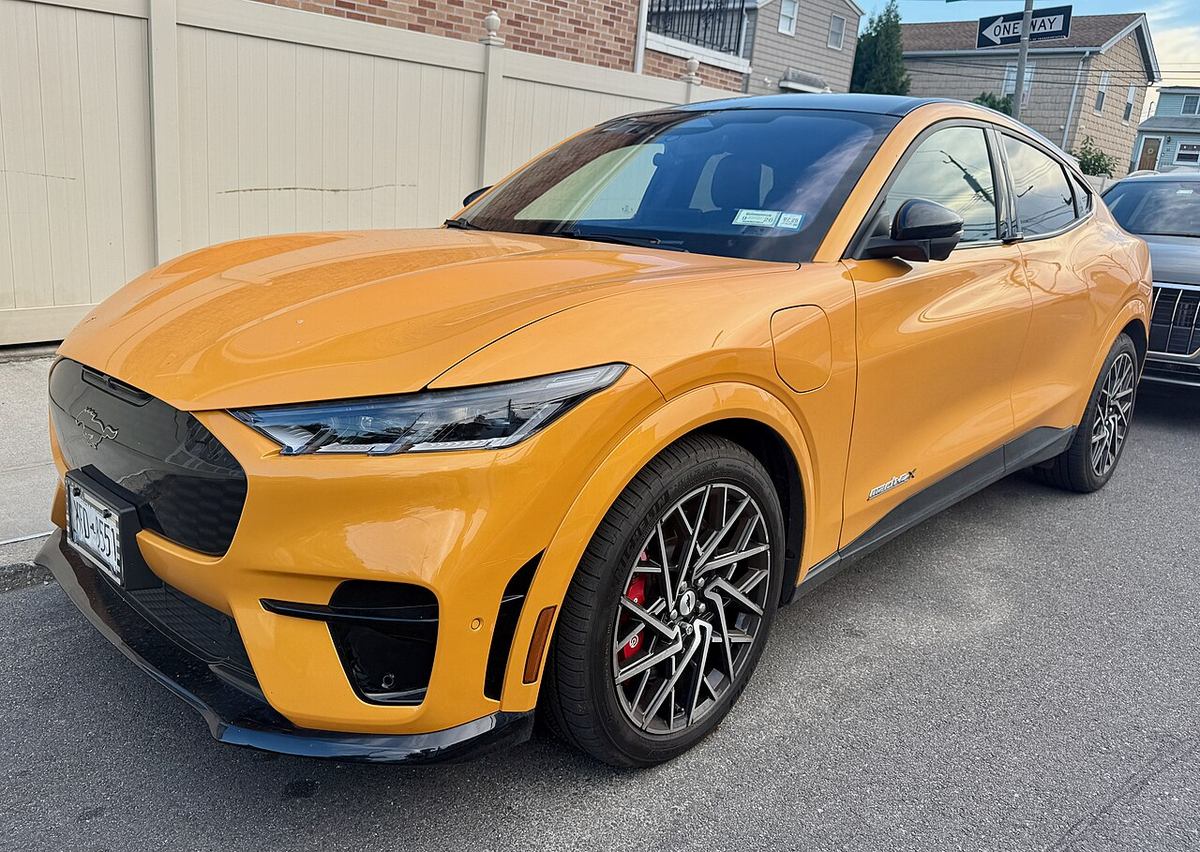 Pomarańczowy Ford Mustang Mach-E 2027 w wersji GT na parkingu