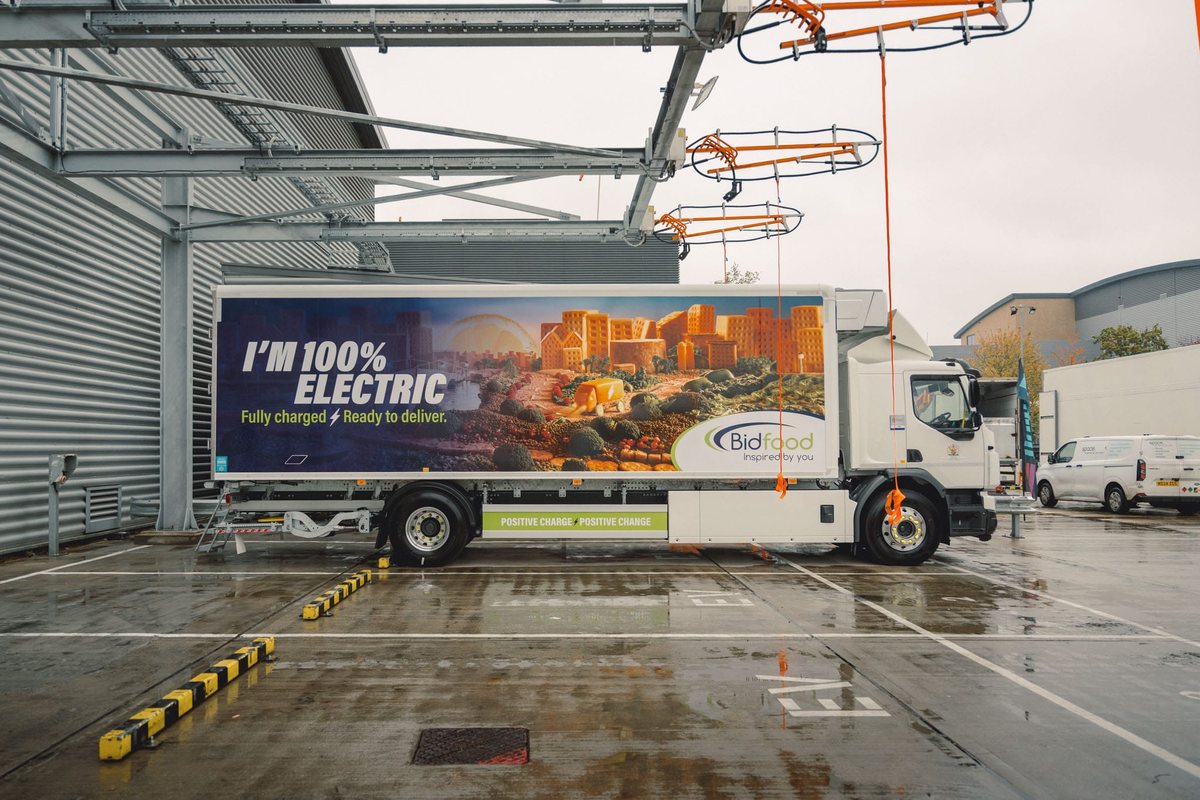 Naczepa Bidfood z hasłem o elektrycznym napędzie przy czterech ramionach ładowania nad dokami