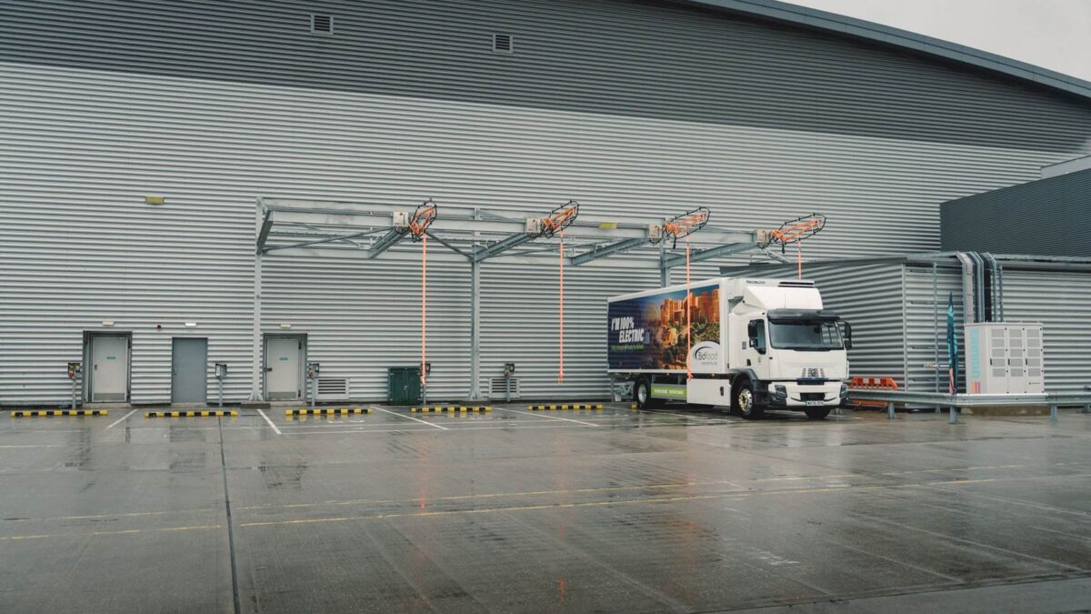 Cztery stanowiska ładowania zawieszone nad dokami zajezdni Bidfood w Slough, obok stoi elektryczna ciężarówka