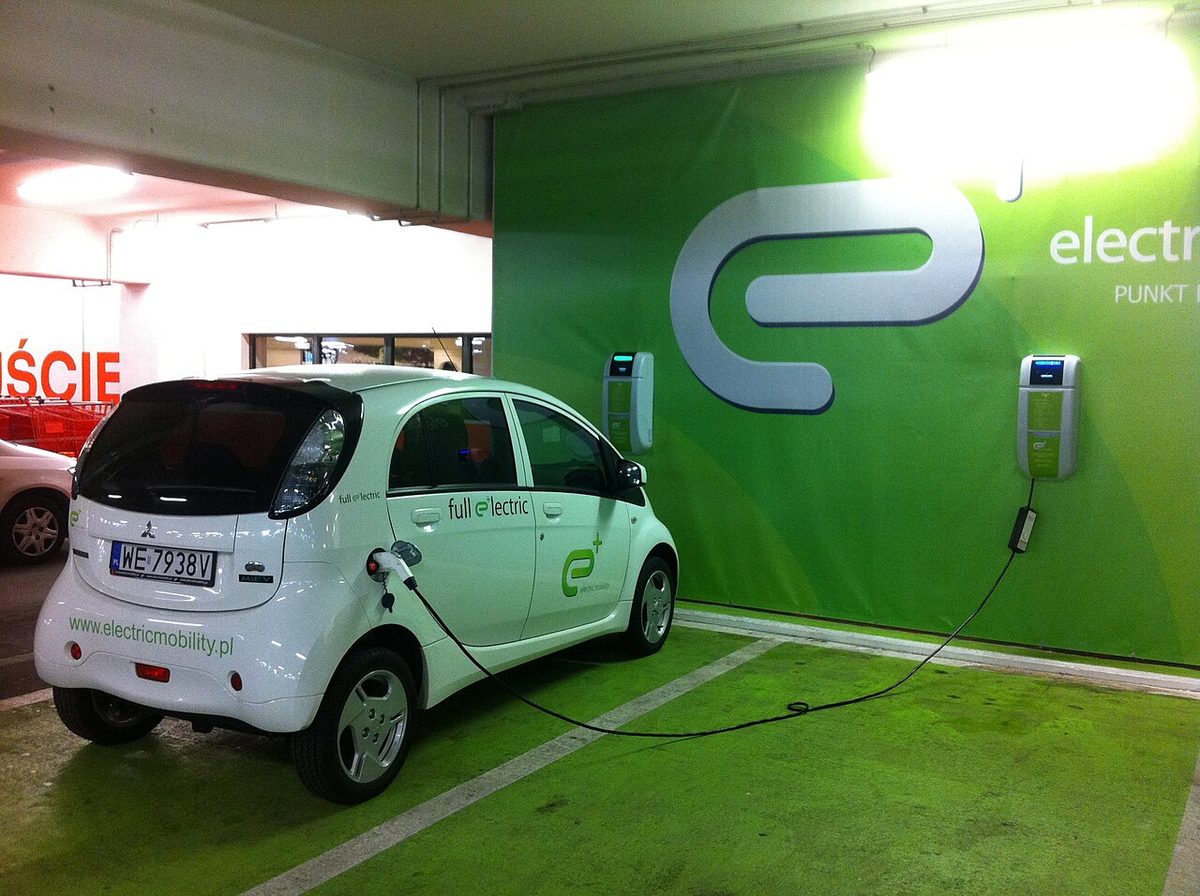Samochód elektryczny ładowany na parkingu centrum handlowego w Warszawie