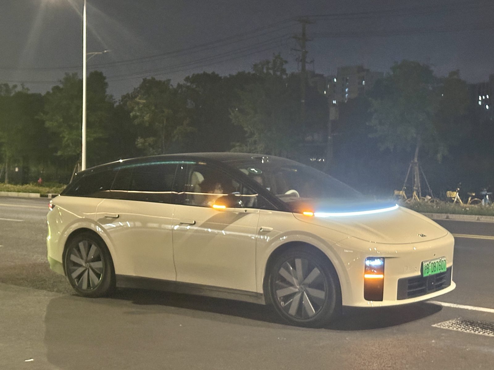 Biały Li Auto i6, elektryczny SUV, zaparkowany nocą na ulicy w chińskim mieście