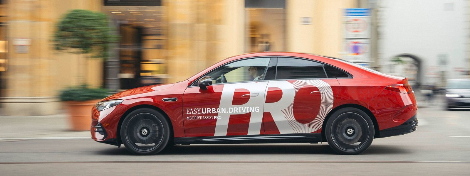 Mercedes-Benz CLA z oklejeniem MB.DRIVE ASSIST PRO na ulicy w mieście