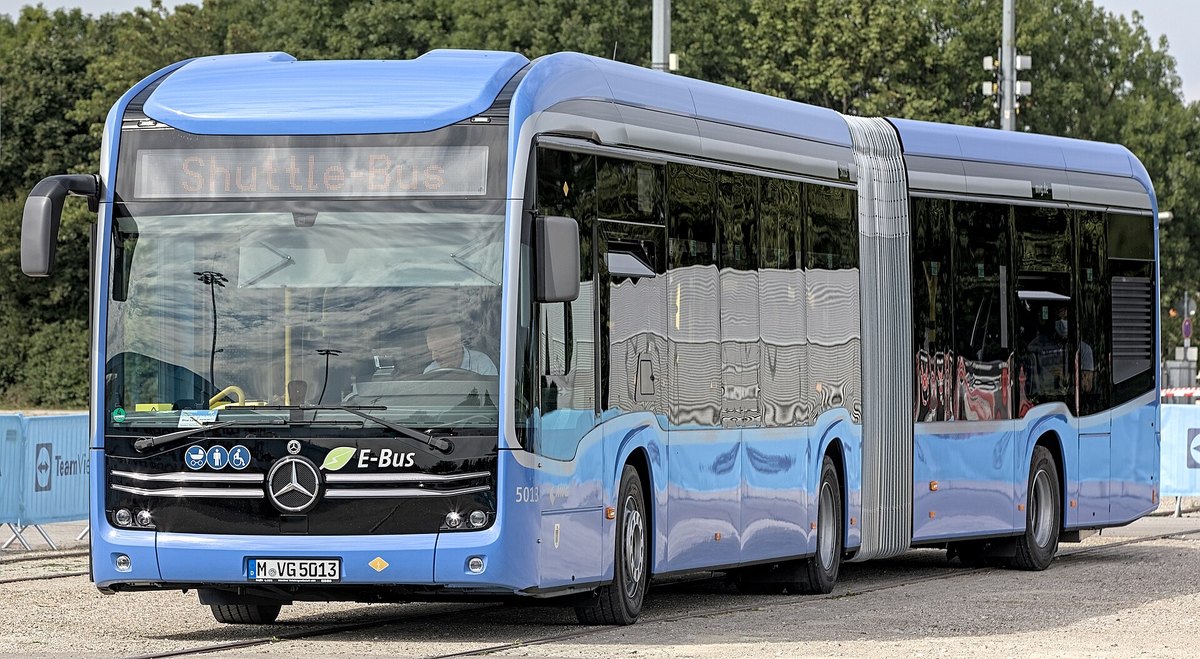 Niebieski przegubowy autobus Mercedes-Benz eCitaro z napisem E-Bus na targach