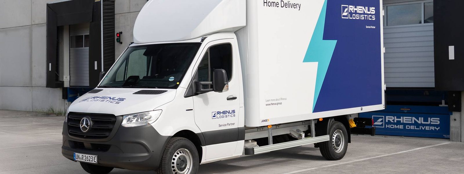 Mercedes-Benz eSprinter dla Rhenus z kontenerową zabudową Home Delivery przed halą