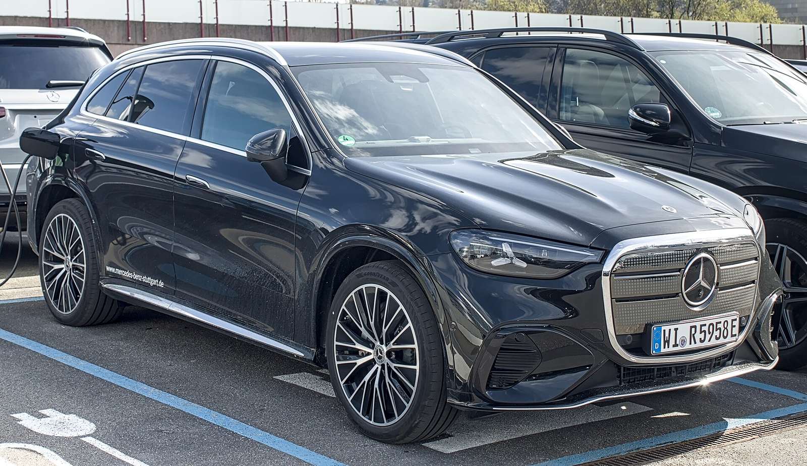 Elektryczny Mercedes-Benz GLC z technologią EQ na parkingu ze stanowiskiem ładowania