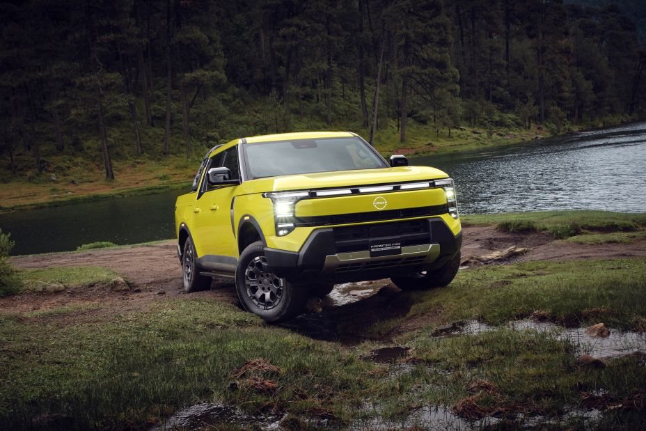 Żółty pickup Nissan Frontier Pro z napędem hybrydowym plug-in zaparkowany nad jeziorem