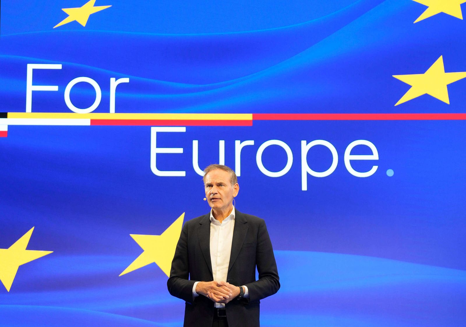 Oliver Blume, prezes Grupy Volkswagen, na scenie wydarzenia For Europe w Paryżu na tle niebieskiego tła z gwiazdami UE