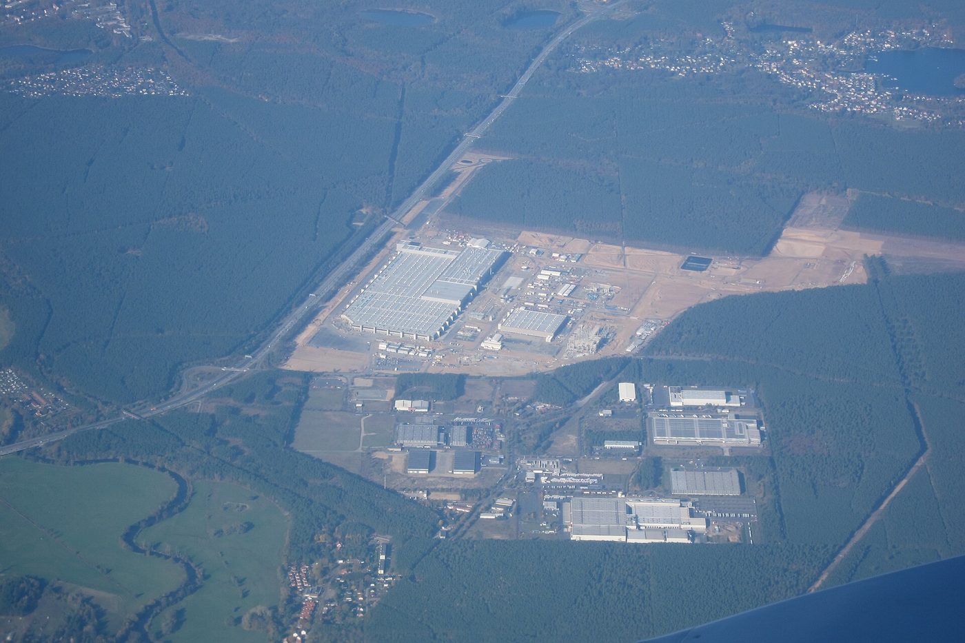 Teren zakładu Tesli w Grünheide w Brandenburgii widziany z samolotu, w otoczeniu lasu