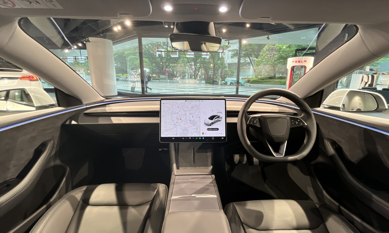Kokpit Tesli z ekranem dotykowym, na którym kierowca ustawia pakiet Tesla Assisted Driving