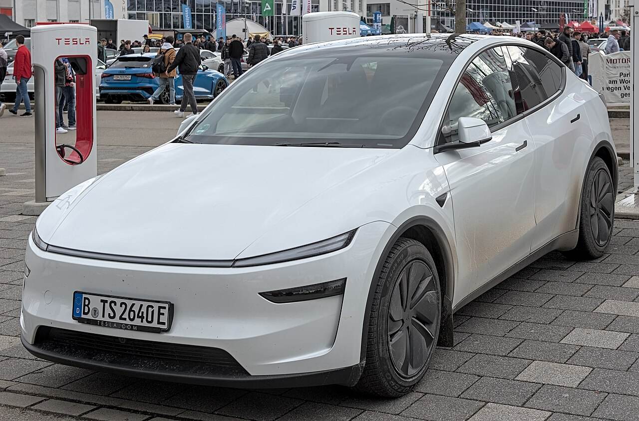 Biały Tesla Model Y z niemiecką tablicą rejestracyjną na ulicy