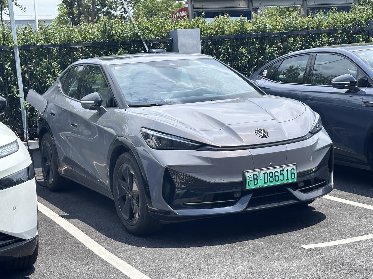 Szary Volkswagen ID. Unyx 06 z chińską tablicą rejestracyjną zaparkowany przy punkcie ładowania