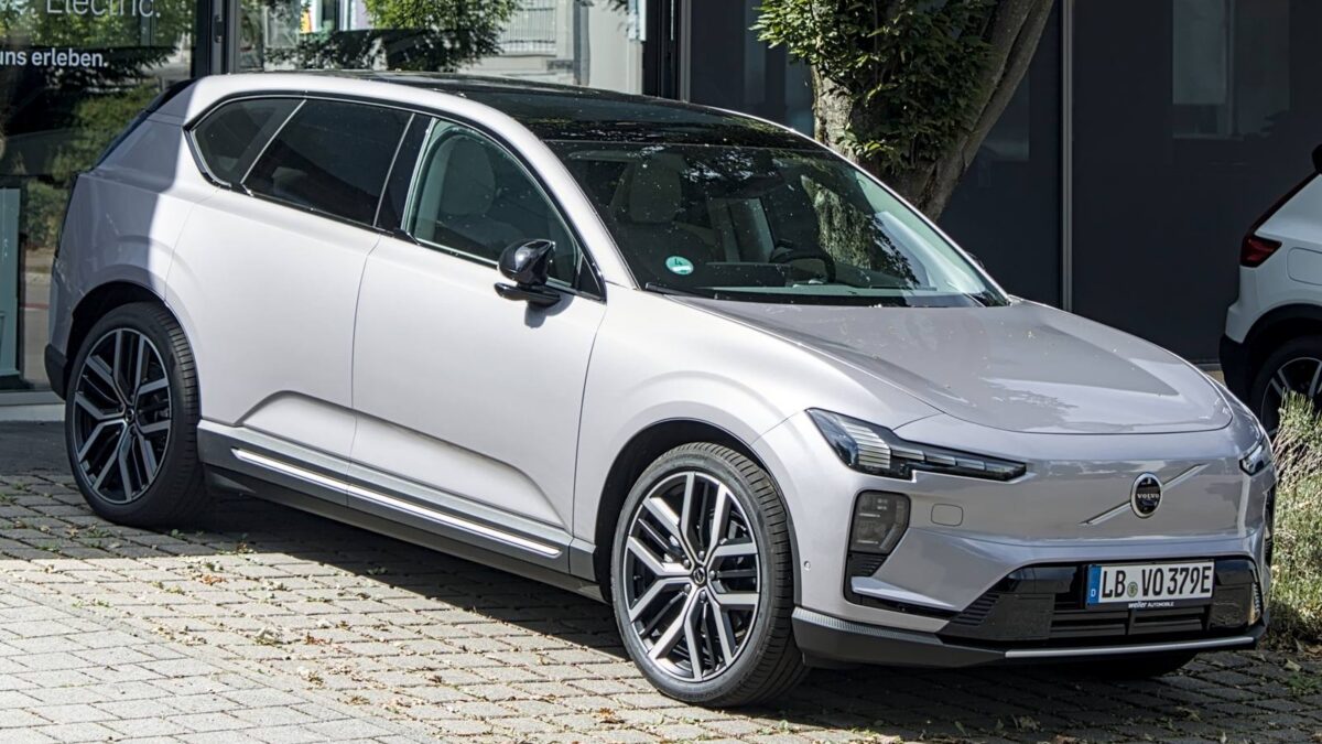 Srebrny elektryczny SUV Volvo EX60 przed salonem samochodowym