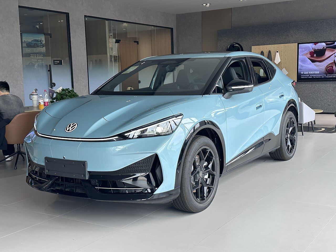 Jasnoniebieski Volkswagen ID. UNYX w salonie sprzedaży, ujęcie z przodu